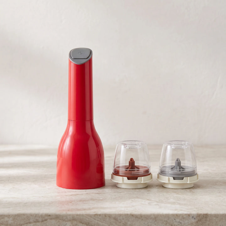 Red electric spice mill with two empty pods