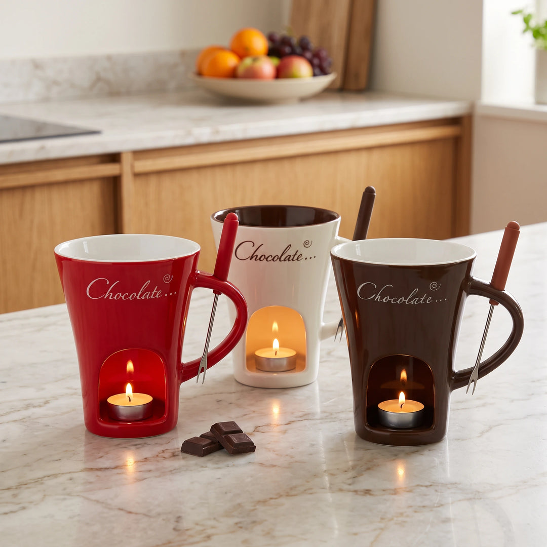 Red, white and brown chocolate fondue mugs with lit tealights on a kitchen counter