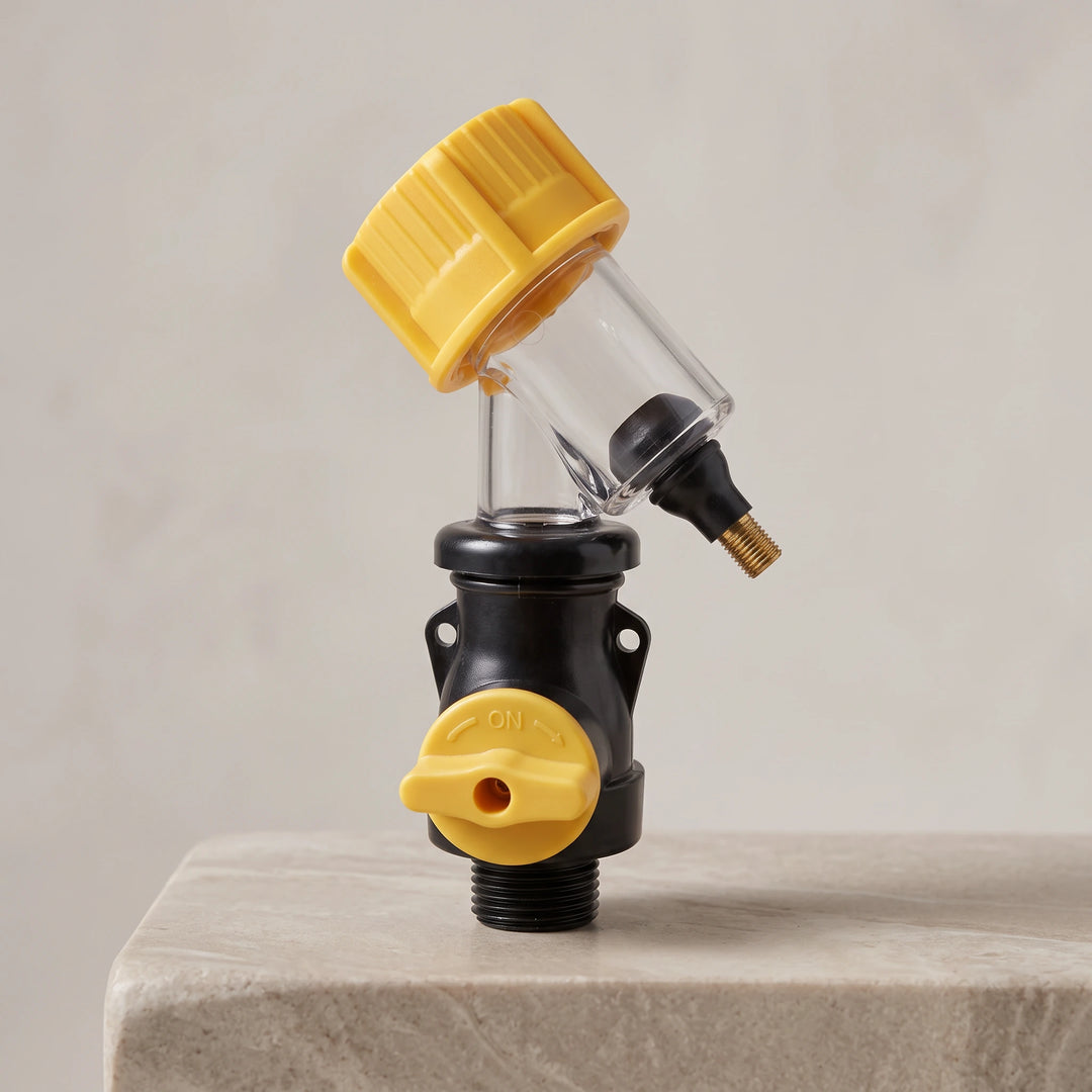 Clear water heater flushing tool with yellow cap and yellow ON valve on a stone plinth